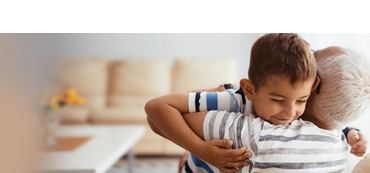 A young child hugging their grandparent